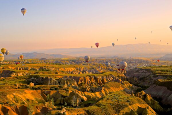 Hot Air Balloons Flying Over Mountain Range